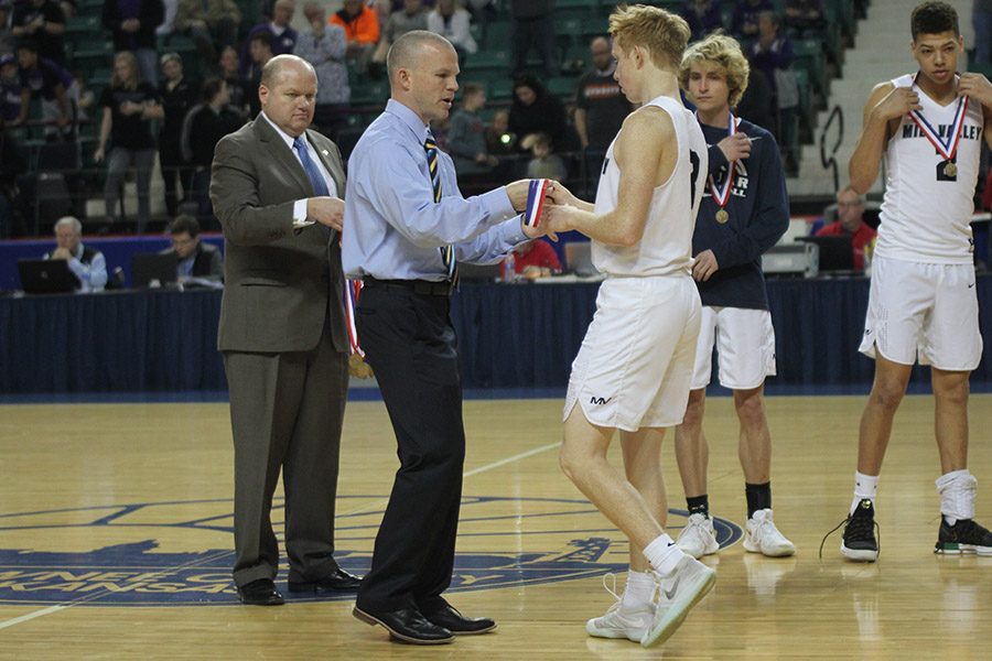 After the game, head coach Mike Bennett presents senior Sammy Rebeck with his fourth place medal. 