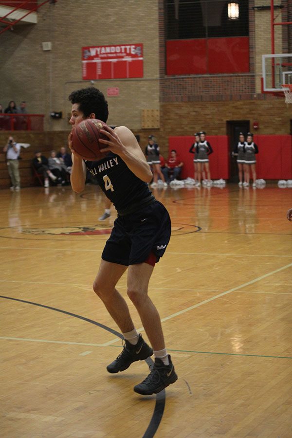 Keeping the ball away from Wyandotte defenders, senior Mason Little looks for a teammate to pass to.