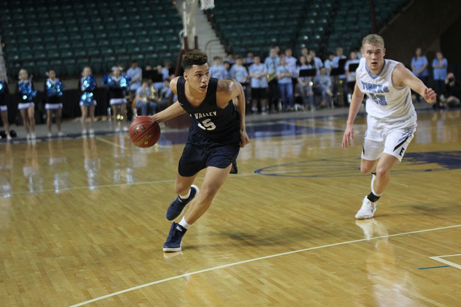 Rushing past an Eisenhower defender, freshman Keeshawn Mason dribbles down the court.