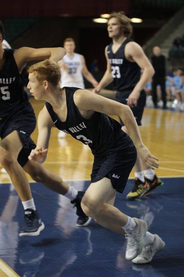 With his eye on the ball, senior Sammy Rebeck rushes to assist his teammate.