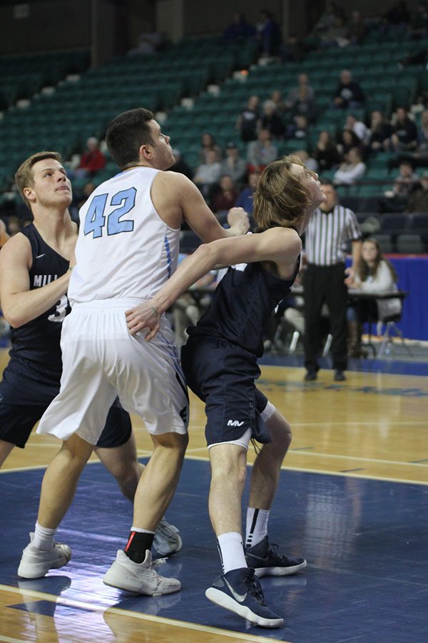 Fighting to get the rebound, senior Ben Weigel blocks an Eisenhower opponent. 