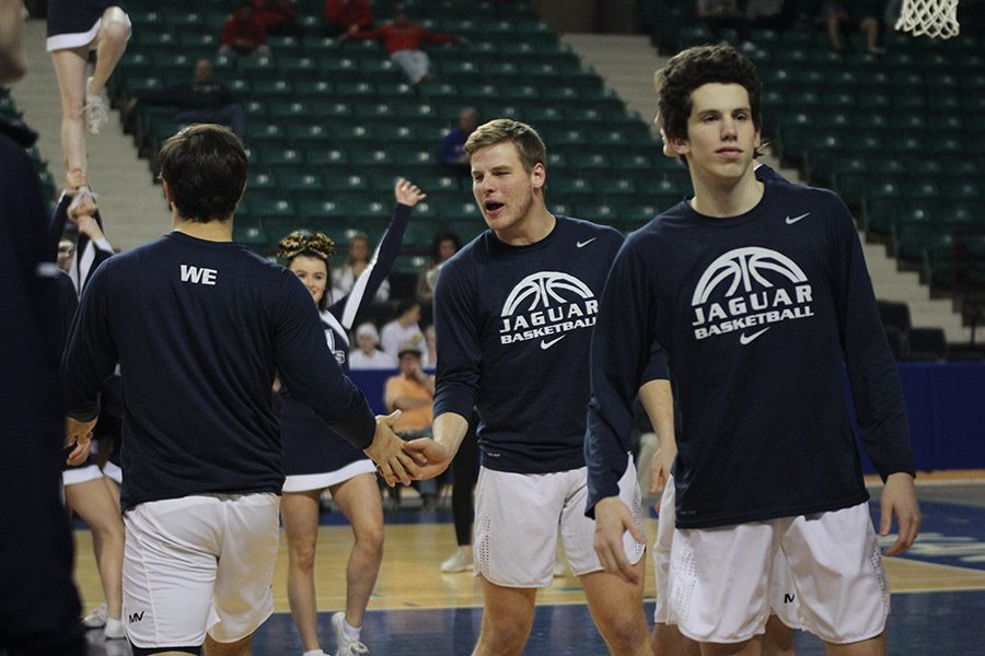 As the starting lineup is announced, senior Brody Flaming high-fives senior Ike Valencia. 