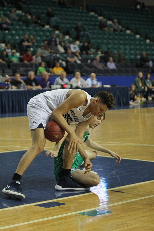 After a Bishop Carroll player hits the floor, freshman Keeshawn Mason gains possession of the ball. 
