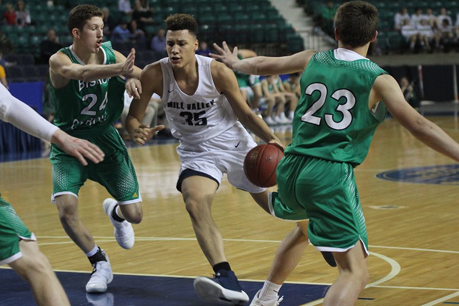 Rushing through Bishop Carroll defenders, freshman Keeshawn Mason goes in for a layup. 