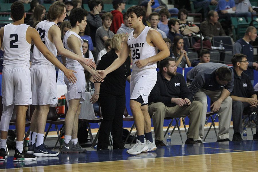 After coming off the court, senior Ike Valencia high-fives his teammates.