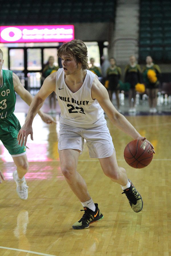 Focused on finding an open path to the basket, senior Cooper Kaifes dribbles the ball down the court.
