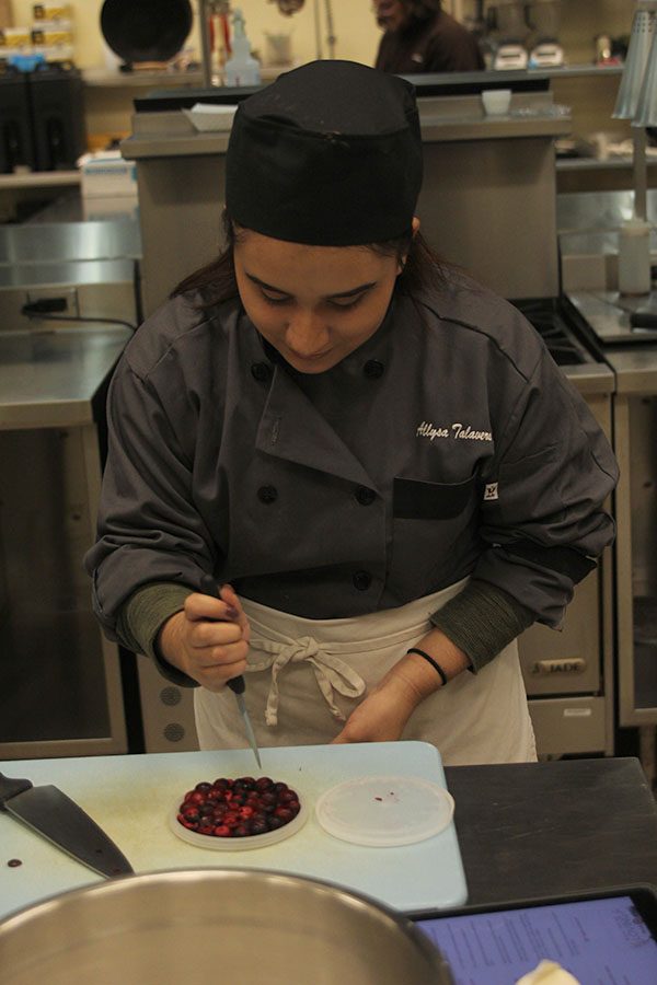 After preparing the first two courses, senior Allysa Talavera finishes cutting the cranberries for the dessert course on Friday, Feb. 23. “I like how it gives us real world experience in an actual kitchen and there’s no sugar coating it,” Talavera said.