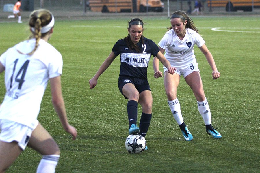 With defenders closing in, freshman Peyton Wagoner controls the ball and looks to turn.