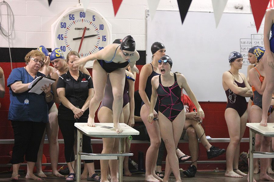 Freshman Kinley Drummond cheers for her teammate junior Emily Proctor as she dives into the water.