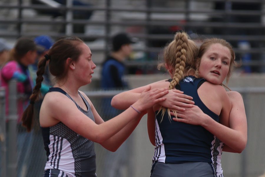 Supporting each other through a hug, junior Delaney Kemp, sophomore Jenna Walker, and freshman Josie Taylor unite after completing the 1600-meter run.