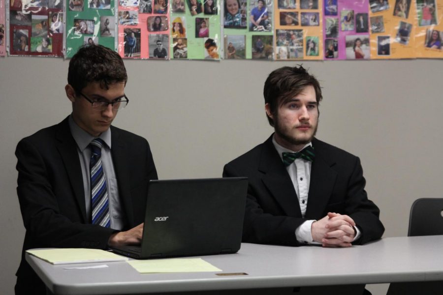 Seniors Jayden Moore and Zolton Gothard listen to other forensics members perform.