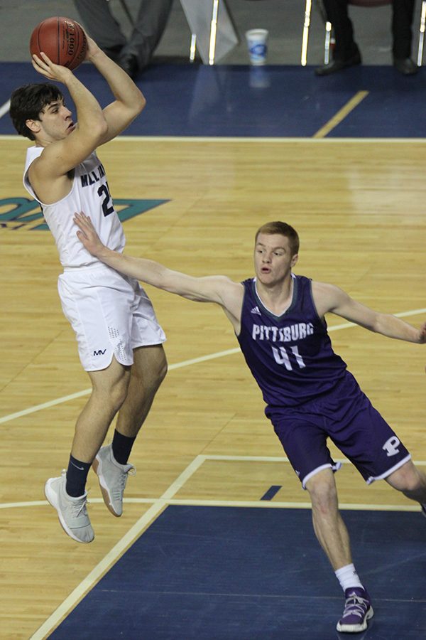 After receiving the ball at the top of the key, senior Ike Valencia dribbles to the free throw line and pulls up for a jump shot. 
