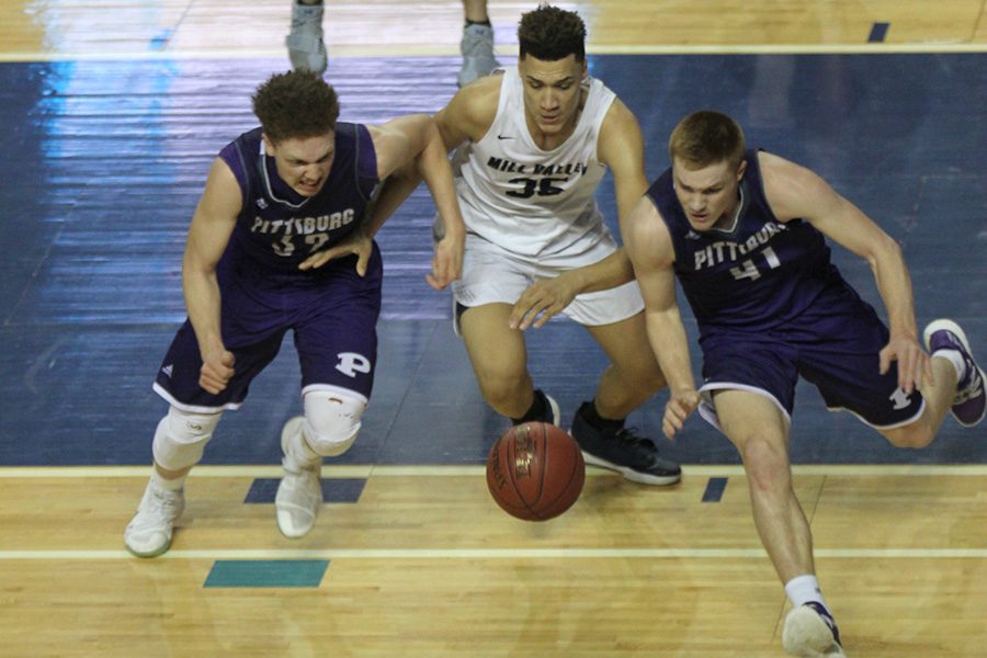 Following a missed shot, freshman Keeshawn Mason competes against two Pittsburg players for the loose ball.
