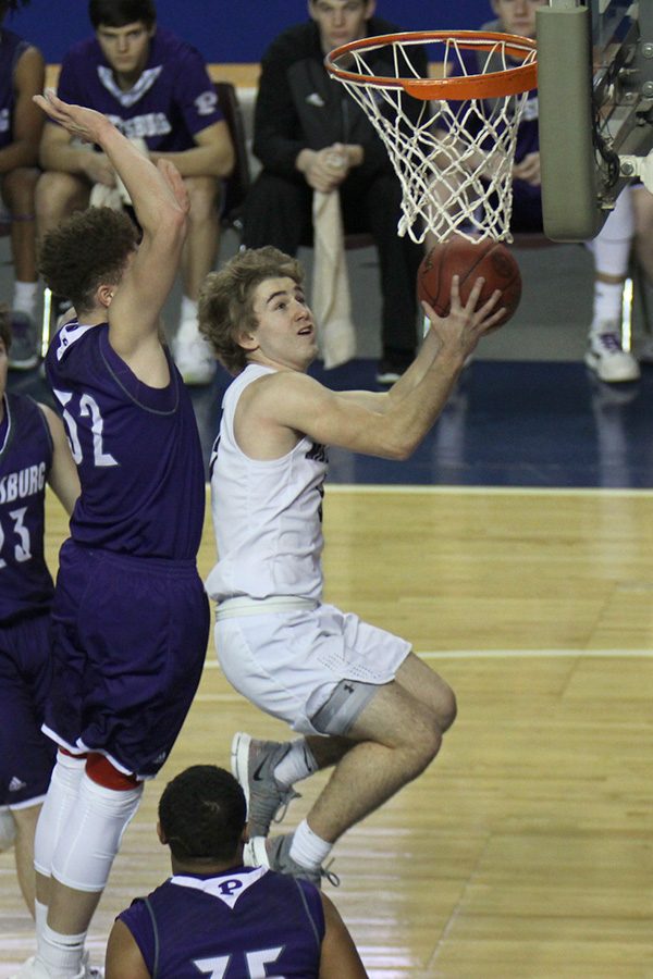 Passing his defenders, junior Logan Talley shoots a layup. 
