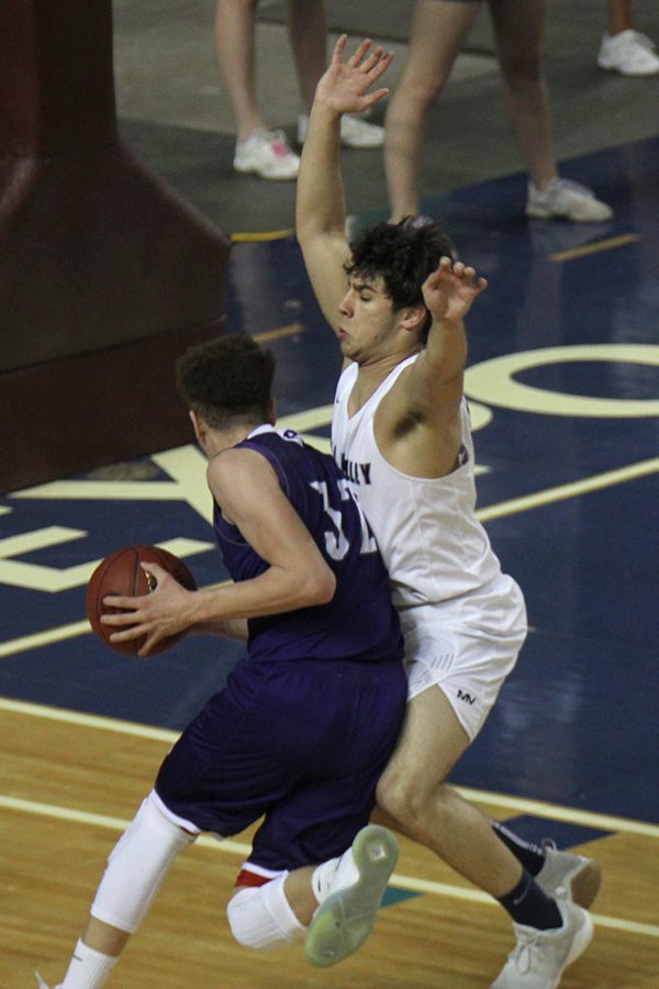 With a Pittsburg player making a break for the basket, senior Ike Vlaencia attempts to move in front of his opponent. 
