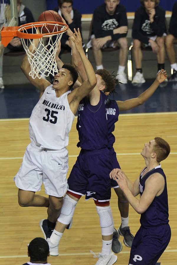 Surrounded by defenders, freshman Keeshawn Mason shoots the ball after an offensive rebound. 
