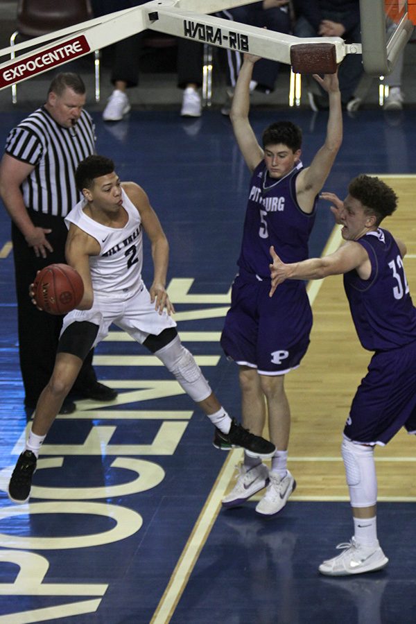 While dribbling along the baseline, junior Matty Wittenaur jumps to pass in order to avoid going out a bounds.
