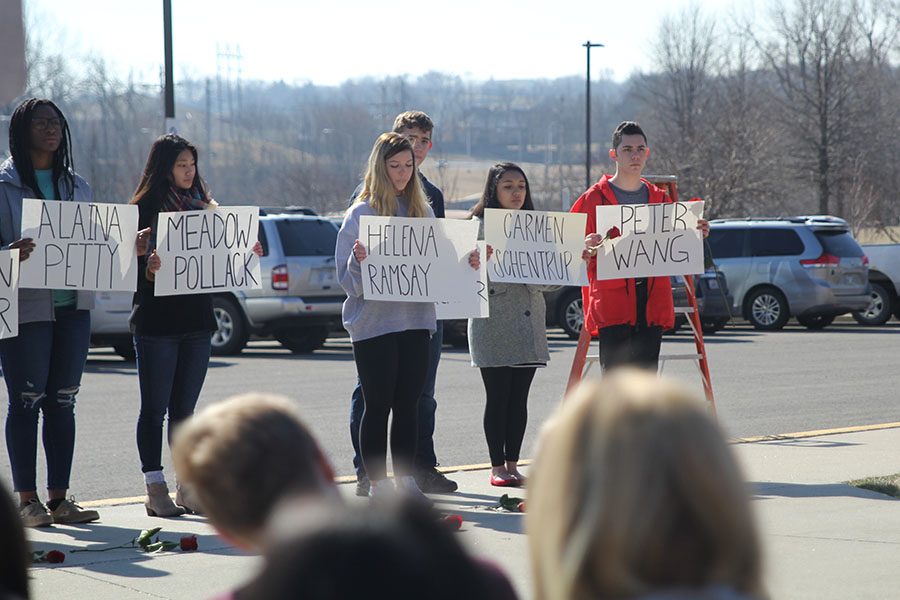 Holding the sign in her hands, junior Lilli Milberger she honors Parkland victim Helena Ramsay.