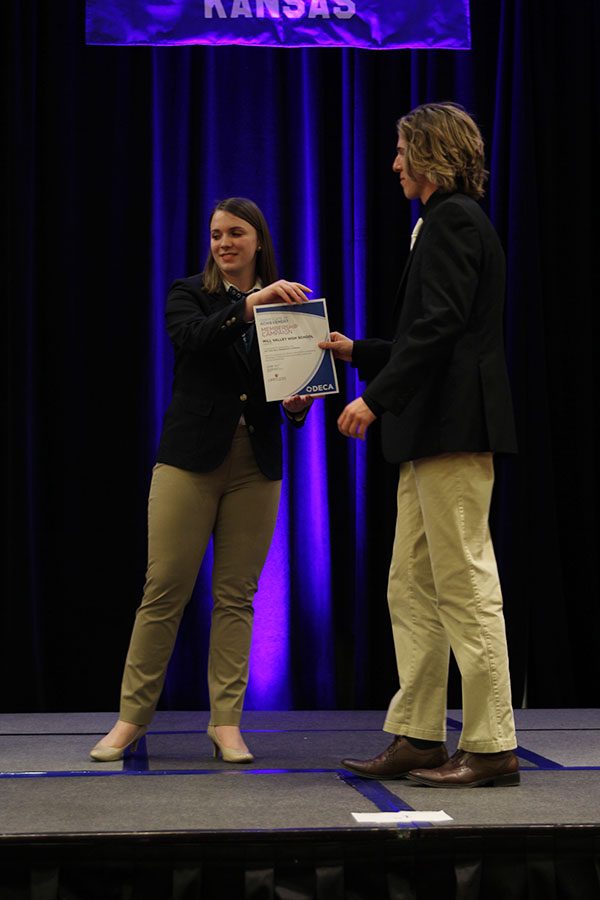 On stage, senior Mitchell Dervin receives a team certificate of achievement award for membership campaign.
