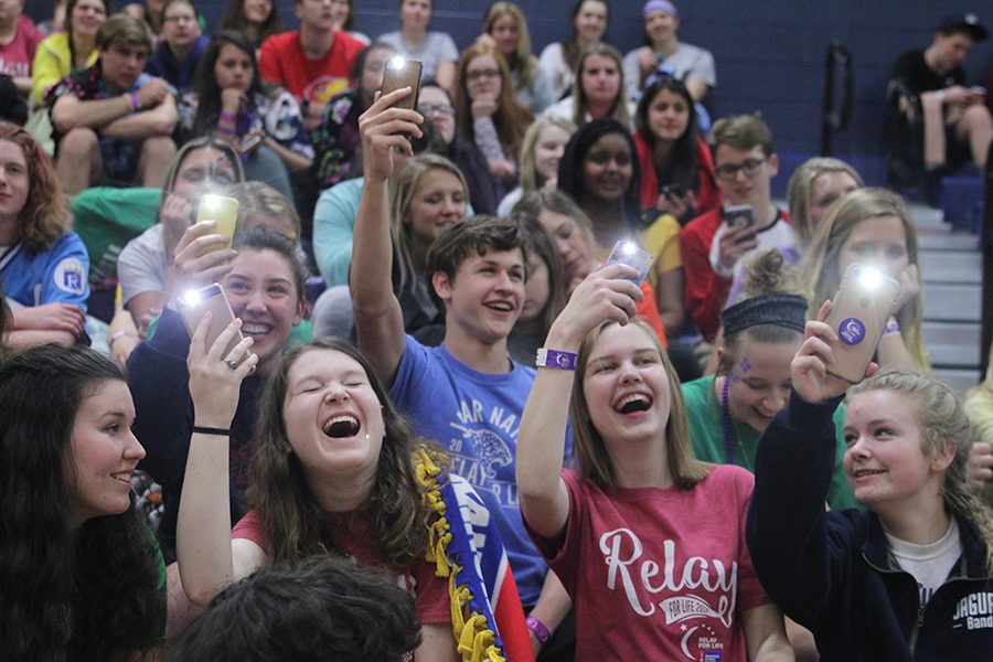 Juniors Analiese Wilhauk and Noah Smith and seniors Julia Feuerborn, Marissa Olin and Katie McNaughton hold up their phones during open mic.