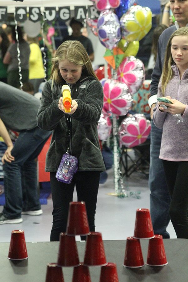 A member of the community shoots a Nerf gun during an on-site fundraiser.