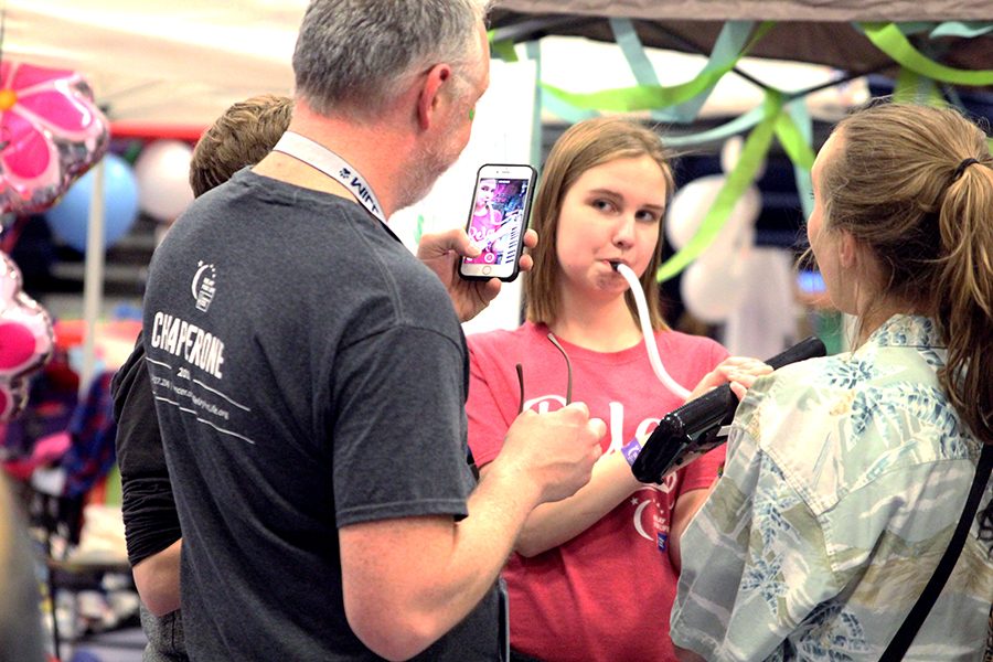Senior Marissa Olin plays her melodica for science teacher Chad Brown during the fundraising part of the night.