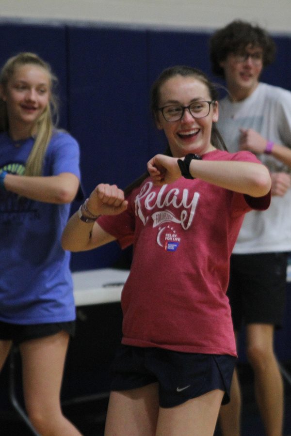 Junior Delaney Kemp smiles while moving during Zumba.