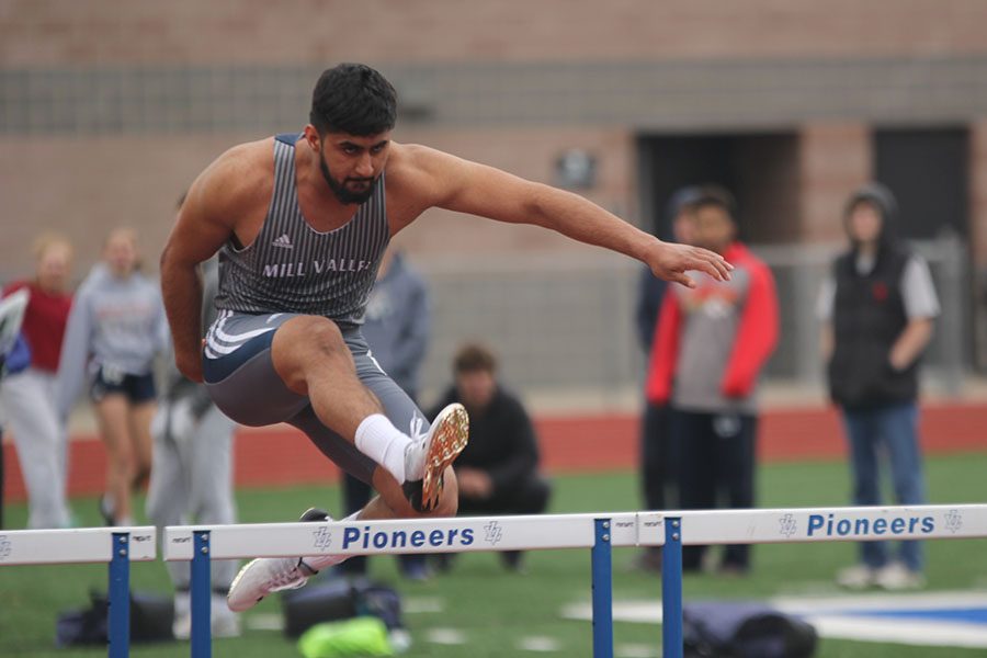 Senior Harjot Singh leaps over a hurdle.