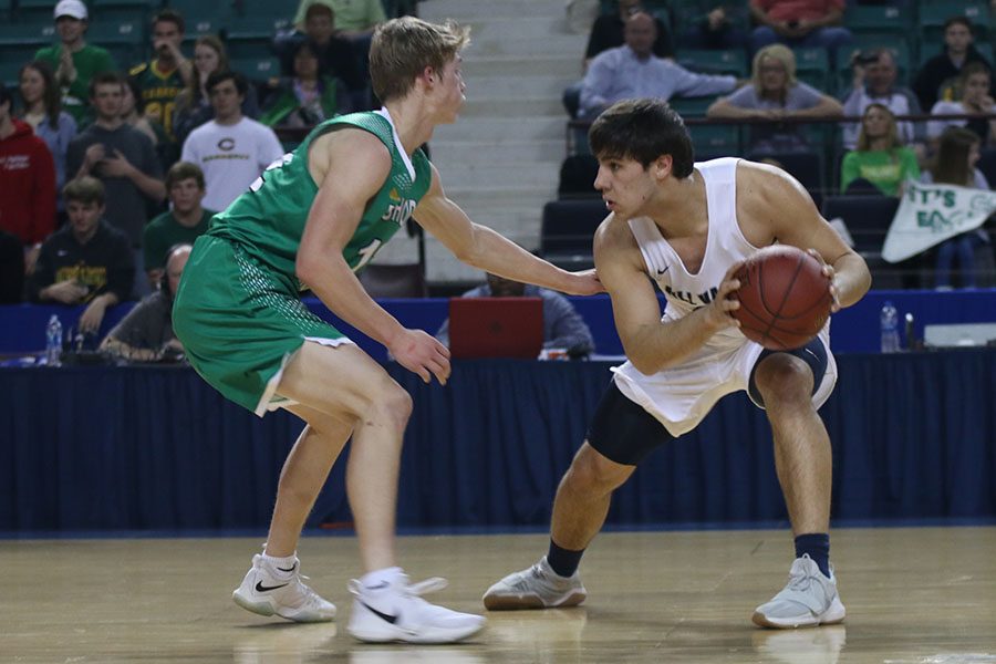 Crouched in a defensive position, senior Ike Valencia defends the ball.