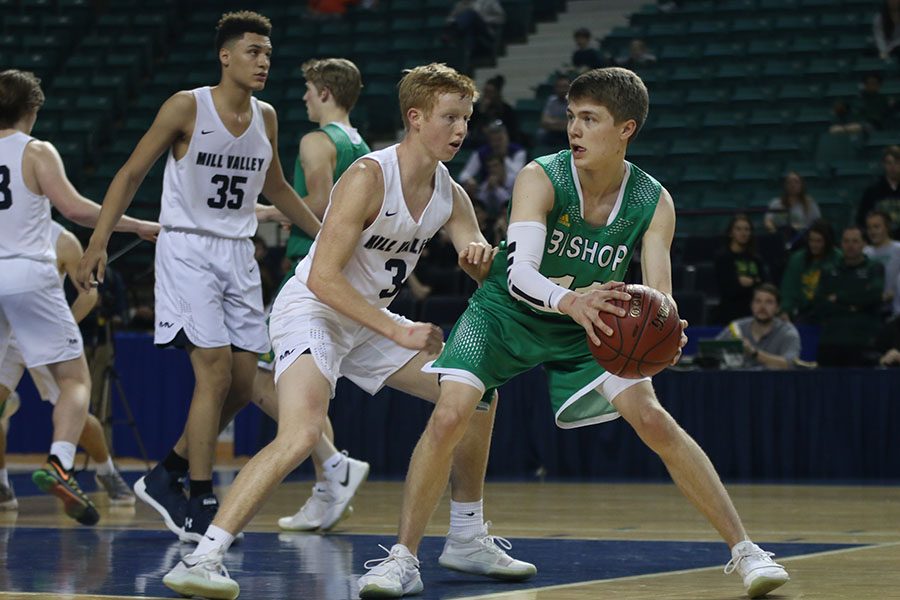 Arm against his opponents back, senior Sammy Rebeck keeps his eyes on the ball as he defends.