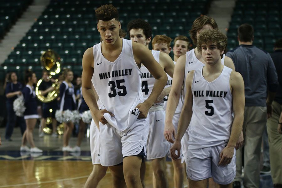 Having lost the game, the team walks over to shake hands with Bishop Carroll team members.