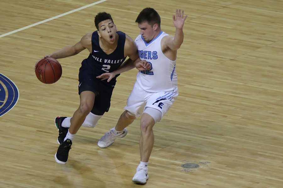 Trying to surpass his opponent, junior Matty Wittenauer advances the ball down the court. Advancing onto the next round, the team won 68-64 against the Eisenhower Tigers. The team is in action again at 4:30 p.m. on Friday, Mar. 9 at Kansas Expocentre.