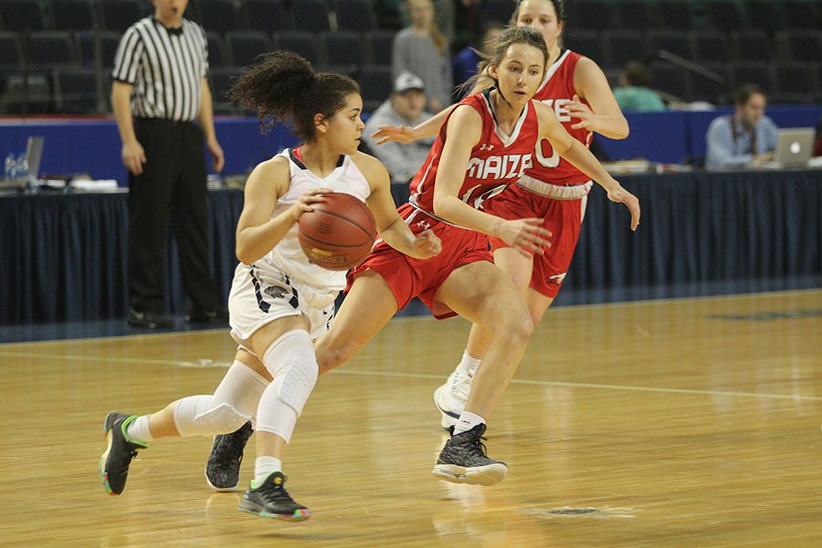 With a defender running alongside her, junior Presley Barton dribbles toward the basket.