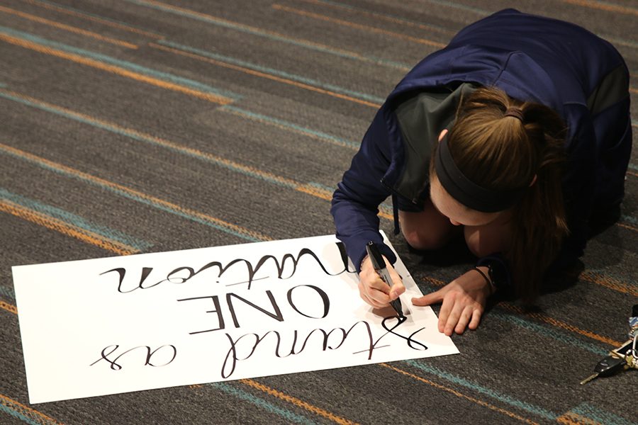 Drawing on a poster board, junior Delaney Kemp prepares signs for the walkout on Monday, March 5. The walkout will take place at 10 a.m. on Thursday, March 8 in remembrance of the victims of the Parkland school shooting. 