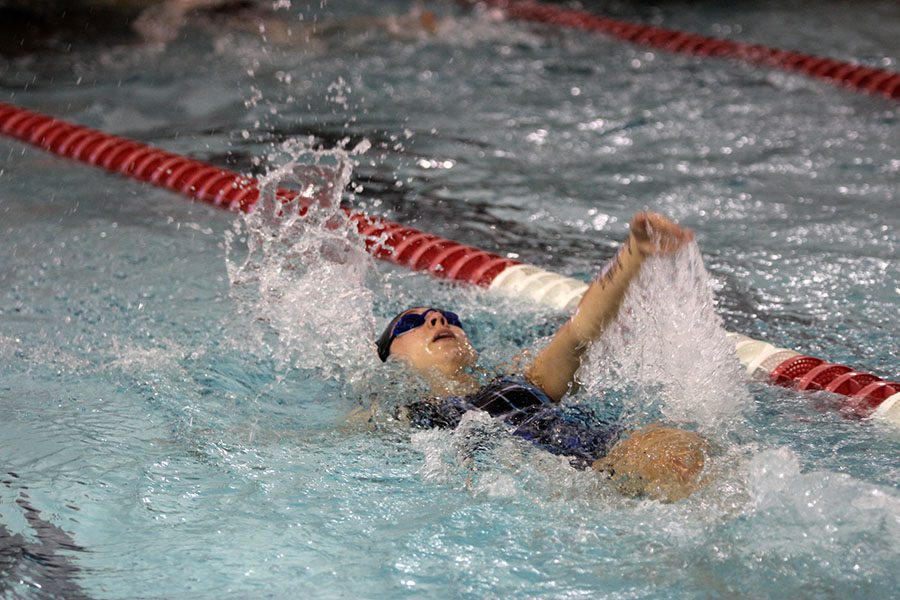 Junior Nicole Wieschhaus swims back stroke.