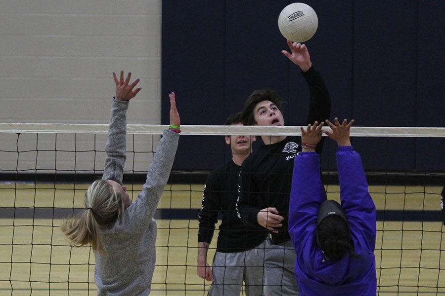 During the Kick Butts volleyball tournament on Wednesday, March 21, senior Brent Stevenson tips the ball over the net as girls from the opposing team attempt to block it. Stevensons team Let the Good Times Bowl took first place in the tournament. 