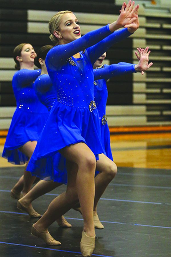 While performing in the large varsity jazz routine during the Olathe Northwest dance showcase on Monday, Feb. 26, junior Bella Line extends her hands towards the audience. 