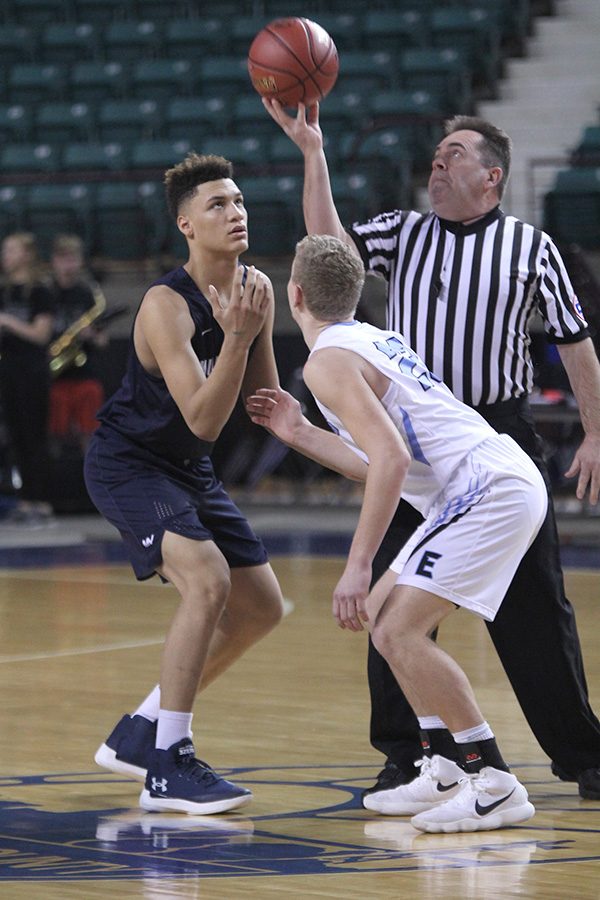 To start the game, freshman Keeshawn Mason prepares to jump for the tipoff. 
