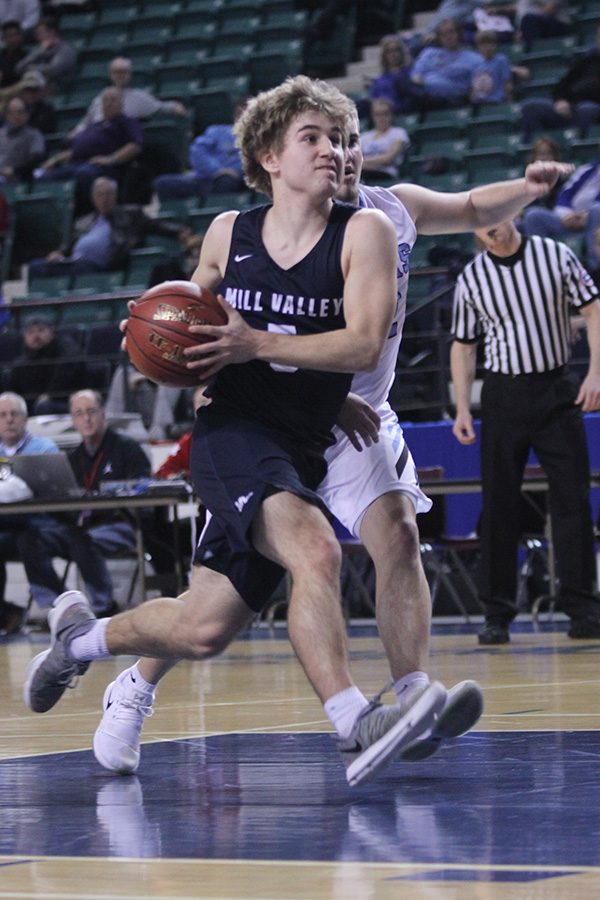 Running by his defender, junior Logan Talley heads to the basket to shoot a layup.
