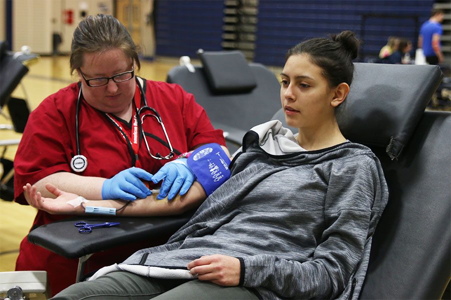 After donating a pint of blood, sophomore Stephanie Madrigal waits for the Red Cross nurse to remove the needle on Thursday, March 22.