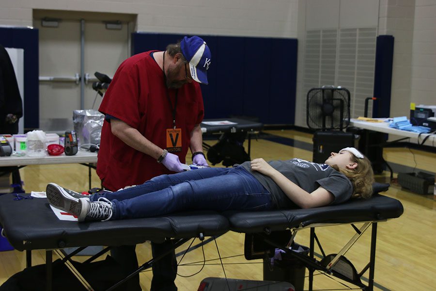 Donating blood for the first time, junior Sydney Clarkin lies down in order to finish her donation.