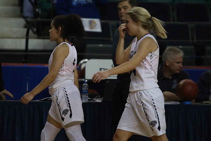 After losing the game, junior Presley Barton and senior Adde Hinkle walk off the court.