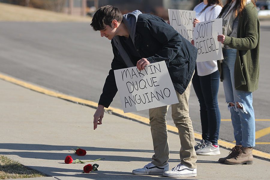 Dropping a rose, senior Travis Scheffler honors Parkland victim Martin Duque Anguiano.