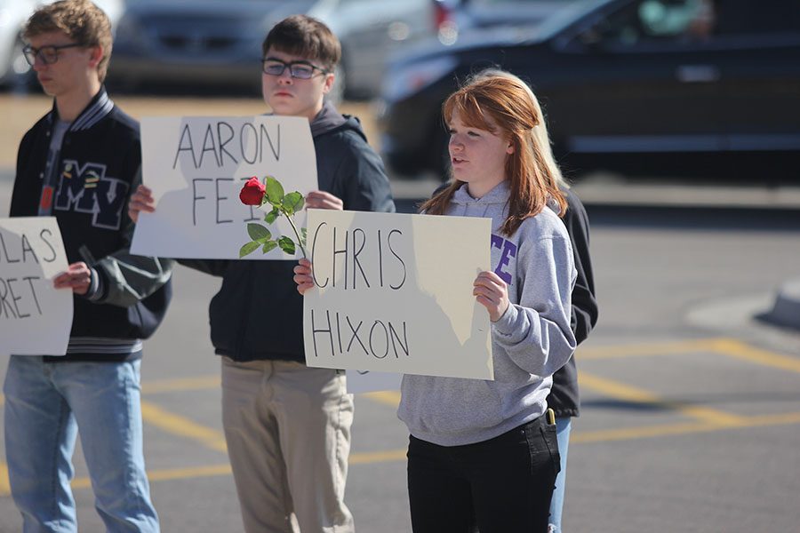 Talking about Parkland victim Chris Hixon, junior Josie Carey holds a sign.