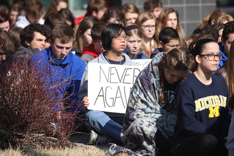 Senior Malcolm Lin holds a sign in hopes of preventing future school violence.