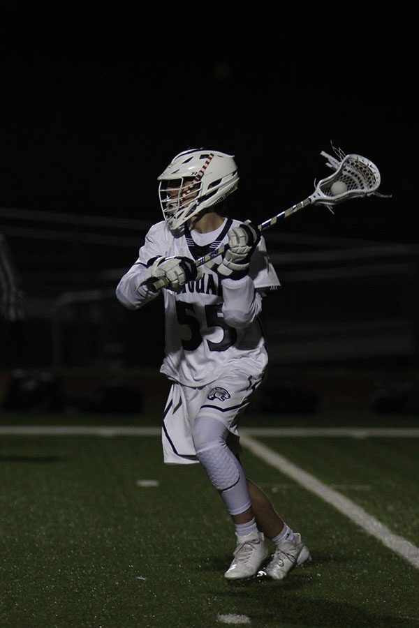 Passing the ball, sophomore Ethan Mantel holds the ball in the net of his stick.