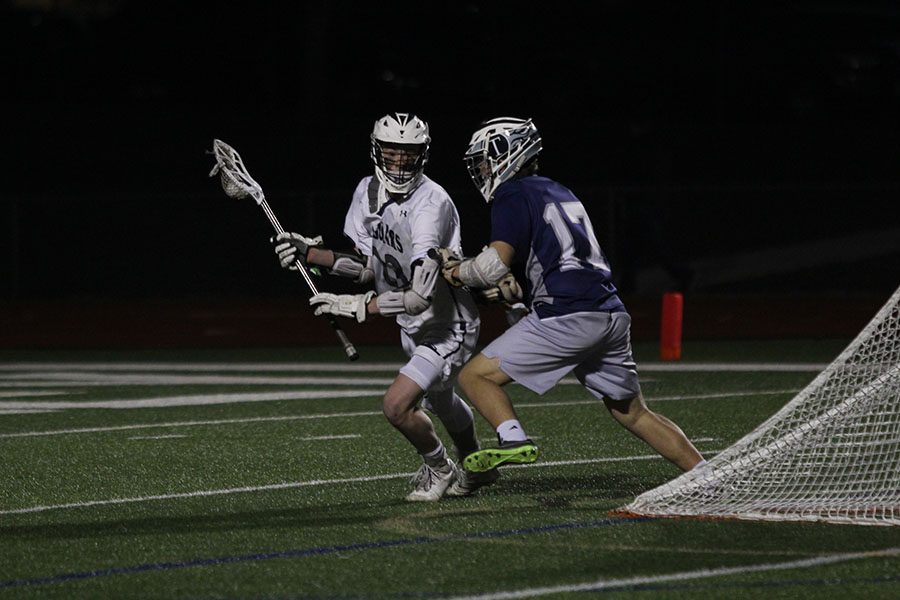 Attempting to shoot, junior Jake Fiscella moves around opponent on Tuesday, March 27.