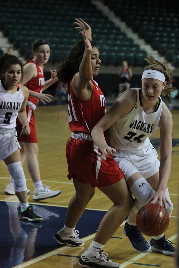 Falling into her opponent, senior Evan Zars attempts to move forward for a layup.
