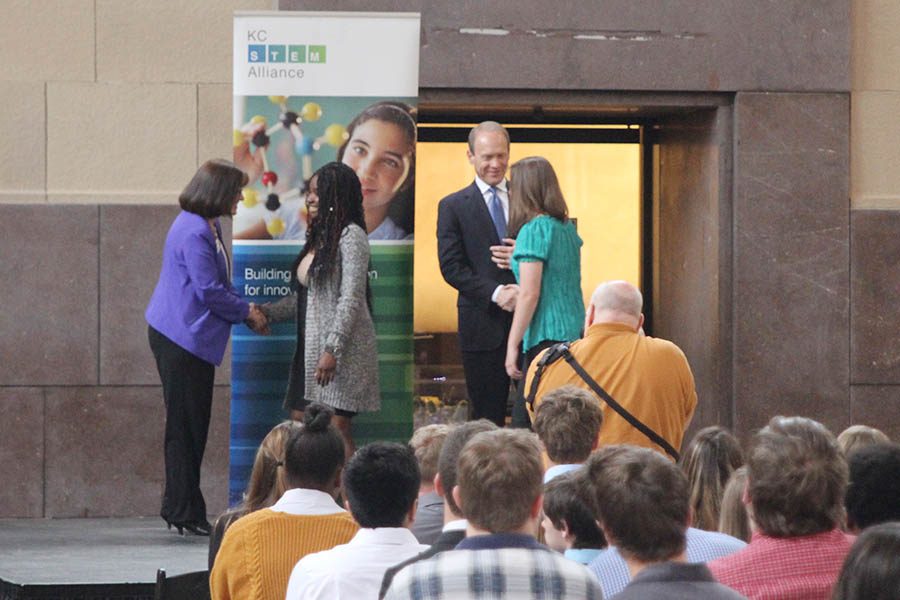 After placing second overall in the engineering category, seniors Desola Ominyi and Christine Lust shake the hands of members of the Kansas City STEM Alliance.