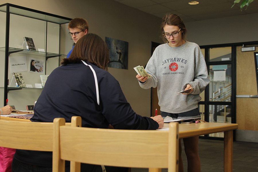 At bank night for Relay for Life, sophomore Avery Altman turns in the rest of her teams money.